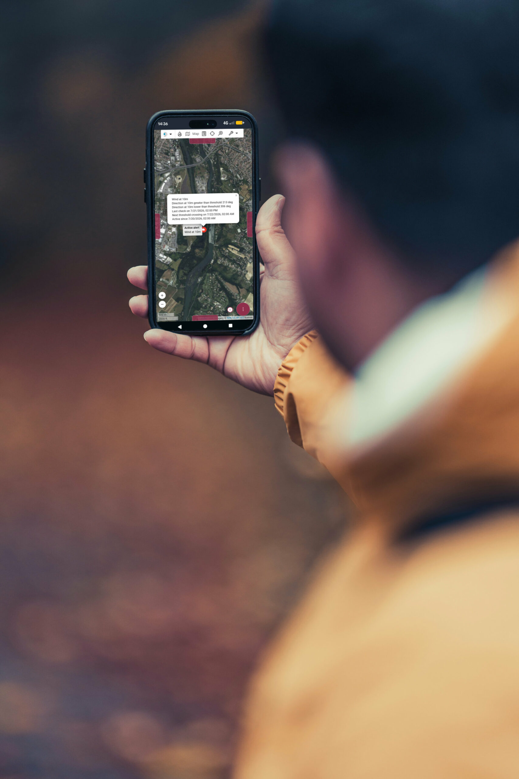 Un homme consulte un événement en cours sur l'application Kalisio Crisis depuis son smartphone
